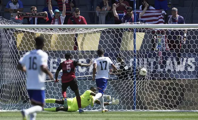 United States forward Malik Tillman (17) scores Trinidad and Tobago defender Justin Garcia (5) and goalkeeper Marvin Phillip, bottom, during the first half of a CONCACAF Gold Cup soccer match in San Jose, Calif., Sunday, June 15, 2025. (AP Photo/Jeff Chiu)