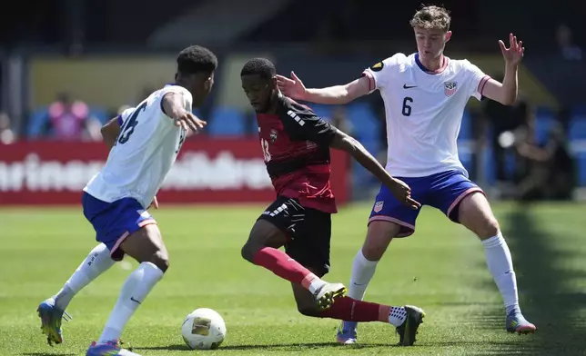 Trinidad and Tobago midfielder Tyrese Spicer, center, brings the ball upfield between United States defender Alexander Freeman, left, and midfielder Jack McGlynn (6) during the first half of a CONCACAF Gold Cup soccer match in San Jose, Calif., Sunday, June 15, 2025. (AP Photo/Jeff Chiu)