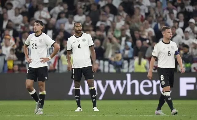 Germany's Jonathan Tah, center, Joshua Kimmich, right, and Aleksandar Pavlovic are dejected after Portugal's Cristiano Ronaldo scored his side's second goal during the Nations League semifinal soccer match between Portugal and Germany at the Munich Football Arena, in Munich, Germany, Wednesday, June 4, 2025. (AP Photo/Matthias Schrader)
