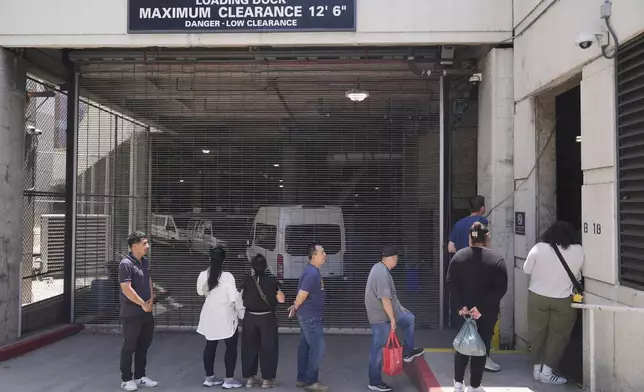 Alejandro Barranco, left, waits in line at the Metropolitan Detention Center to check on his father Narciso, who was recently detained by federal agents, on Monday, June 23, 2025, in Los Angeles. (AP Photo/Damian Dovarganes)