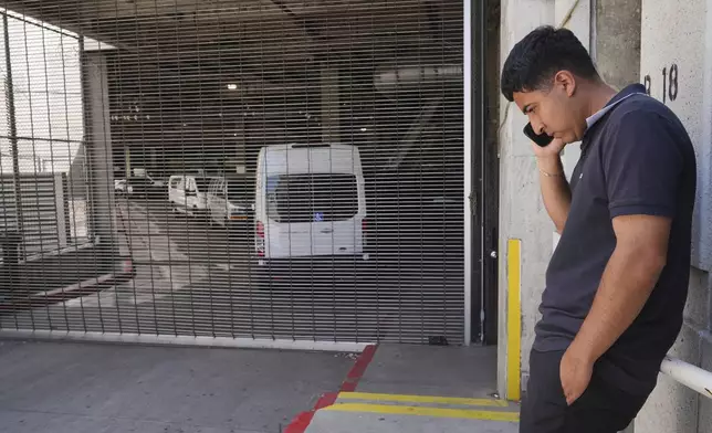 Alejandro Barranco talks on his cell phone outside the Metropolitan Detention Center, where is father Narciso is detained, on Monday, June 23, 2025, in Los Angeles. (AP Photo/Damian Dovarganes)