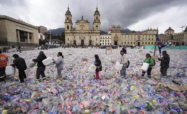 Recyclers wade through plastic bottles blanketing Plaza Bolivar in Bogota, Colombia, as they protest against what recyclers consider to be too low a price paid to them by companies that buy recycled materials, Tuesday, June 24, 2025. (AP Photo/Fernando Vergara)