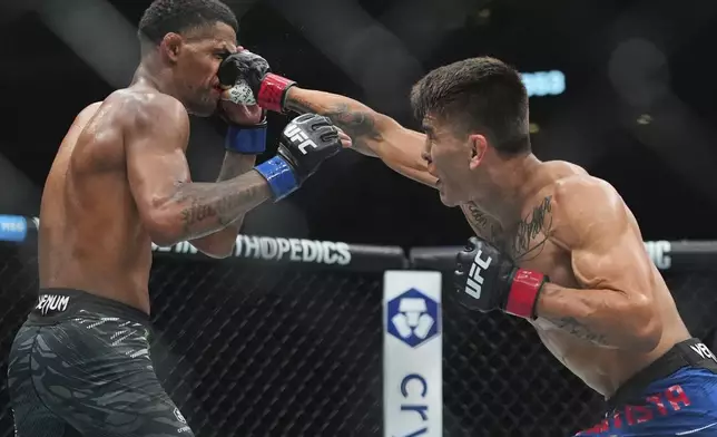 Mario Bautista, right, punches Patchy Mix during the second round of a light bantamweight bout at the UFC 316 mixed martial arts event Saturday, June 7, 2025 in Newark, N.J. (AP Photo/Frank Franklin II)