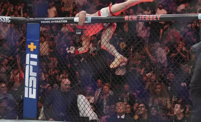 Georgia's Merab Dvalishvili, left, rushes to greet President Donald Trump after a bantamweight title bout at against Sean O'Malley during the UFC 316 mixed martial arts event Sunday, June 8, 2025 in Newark, N.J. (AP Photo/Frank Franklin II)