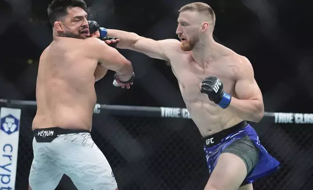Joe Pyfer, right, punches Kelvin Gastelum during the first round of a middleweight bout at the UFC 316 mixed martial arts event Saturday, June 7, 2025 in Newark, N.J. (AP Photo/Frank Franklin II)