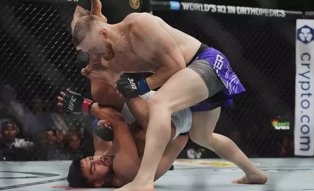 Joe Pyfer, right, punches Kelvin Gastelumduring the first round of a middleweight bout at the UFC 316 mixed martial arts event Saturday, June 7, 2025 in Newark, N.J. (AP Photo/Frank Franklin II)
