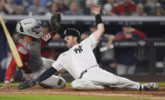 New York Yankees' Austin Wells, right, slides past Boston Red Sox catcher Carlos Narváez to score on a single during the fifth inning of a baseball game, Friday, June 6, 2025, in New York. (AP Photo/Frank Franklin II)