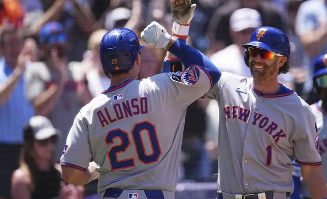 New York Mets' Jeff McNeil, right, congratulates Pete Alonso as he returns to the dugout after hitting a two-run home run off Colorado Rockies starting pitcher Chase Dollander in the third inning of a baseball game Sunday, June 8, 2025, in Denver. (AP Photo/David Zalubowski)