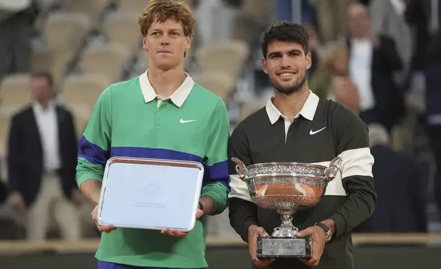 Winner Spain's Carlos Alcaraz, right, and second placed Italy's Jannik Sinner pose with trophies after the final match of the French Tennis Open at the Roland-Garros stadium in Paris, Sunday, June 8, 2025. (AP Photo/Thibault Camus)