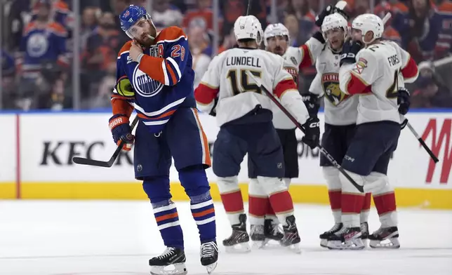 Edmonton Oilers center Leon Draisaitl (29) skates to the bench as Florida Panthers center Eetu Luostarinen (27) celebrates with teammates after scoring an empty-net goal during the third period in Game 5 of the NHL hockey Stanley Cup Final in Edmonton, Alberta, Saturday, June 14, 2025. (Darryl Dyck/The Canadian Press via AP)