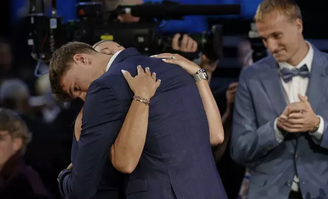 Cooper Flagg hugs family members after being selected first overall by the Dallas Mavericks In the first round of the NBA basketball draft, Wednesday, June 25, 2025, in New York. (AP Photo/Adam Hunger)