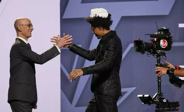 Dylan Harper greets NBA commissioner Adam Silver after being selected second by the San Antonio Spurs In the first round of the NBA basketball draft, Wednesday, June 25, 2025, in New York. (AP Photo/Adam Hunger)