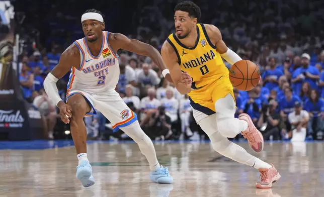 Indiana Pacers guard Tyrese Haliburton (0) drives past Oklahoma City Thunder guard Shai Gilgeous-Alexander (2) during the second half of Game 5 of the NBA Finals basketball series, Monday, June 16, 2025, in Oklahoma City. (AP Photo/Kyle Phillips)