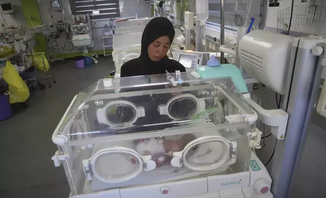 Seham Fawzy Khodeir watches her son, Hisham, who is just days old and was born prematurely, lying in an incubator at the neonatal intensive care unit of Nasser Hospital in Khan Younis, southern Gaza Strip, Thursday, June 19, 2025. (AP Photo/Mariam Dagga)