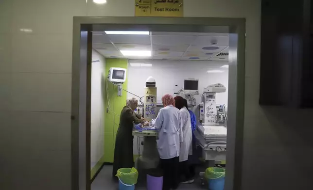 A mother watches as her prematurely born baby is examined at the neonatal intensive care unit of Nasser Hospital in Khan Younis, southern Gaza Strip, Thursday, June 19, 2025. (AP Photo/Mariam Dagga)