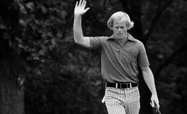 FILE - Johnny Miller, of Hilton Head Island S.C., who started his final Open round Sunday, June 17, 1973 six strokes behind the leaders and 3-over par 216, takes over fourth round lead with a charging 5-under par by birdie on the 15th, where he raises his hand after sinking the putt in Oakmont, Pa. (AP Photo, file)