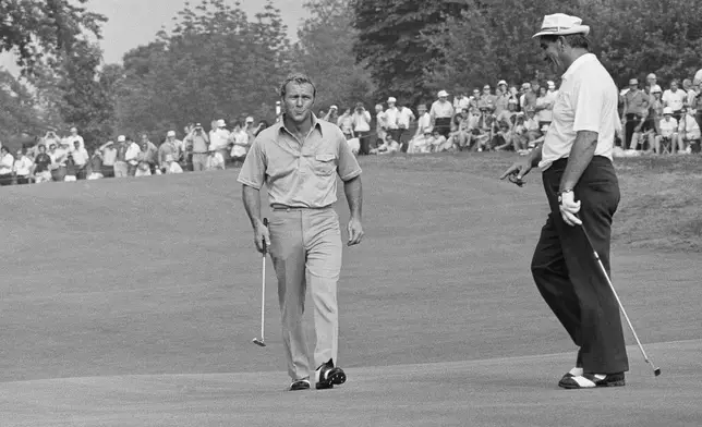 FILE - Arnold Palmer, left, swings his club as he and Julius Boros walk on to green at Oakmont Country Club at Oakmont, Penn., where they were in a four-way tie for the lead in the end of third round of the U.S. Open Golf Championship, June 16, 1973. Palmer, Boros, Jerry Hear and John Schlee all had 3 under 210. (AP Photo/File)