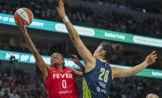 Indiana Fever guard Kelsey Mitchell (0) goes up for a basket against Dallas Wings center Li Yueru (28) during the first half of a WNBA basketball game Friday, June 27, 2025, in Dallas. (AP Photo/Julio Cortez)