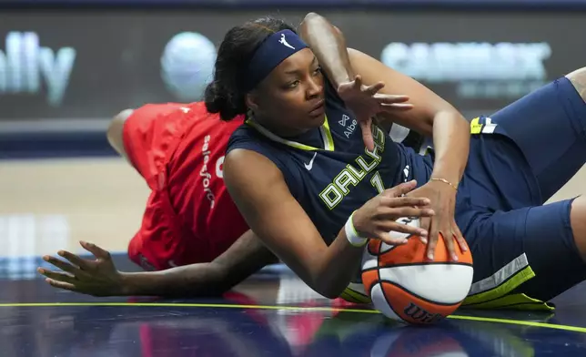 Dallas Wings forward NaLyssa Smith, front, and Indiana Fever forward Natasha Howard, back, compete for the ball during the first half of a WNBA basketball game Friday, June 27, 2025, in Dallas. (AP Photo/Julio Cortez)
