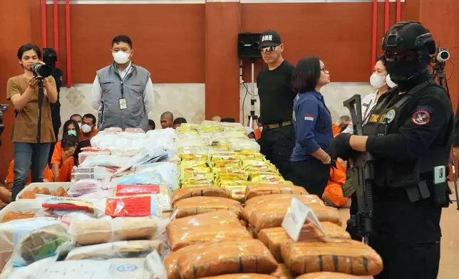 Indonesian police officers stand guard near various drugs seized in a nationwide crackdown in the past few months, before the start of a press conference at the Indonesian Customs headquarters in Jakarta, Indonesia, Monday, June 23, 2025. (AP Photo/Achmad Ibrahim)