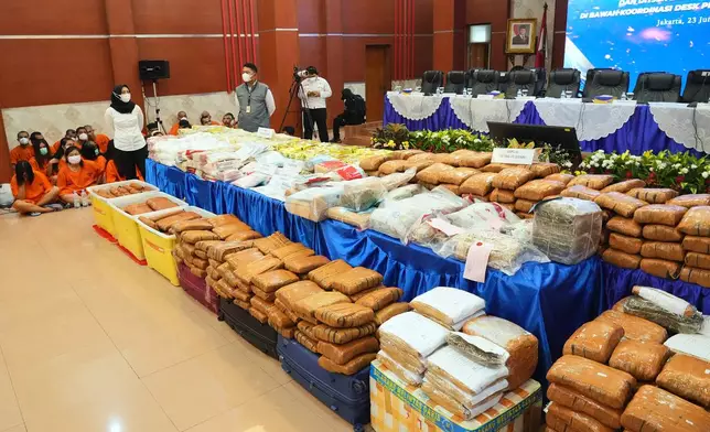 Indonesian police officers stand guard near various drugs seized in a nationwide crackdown in the past few months, before the start of a press conference at the Indonesian Customs headquarters in Jakarta, Indonesia, Monday, June 23, 2025. (AP Photo/Achmad Ibrahim)
