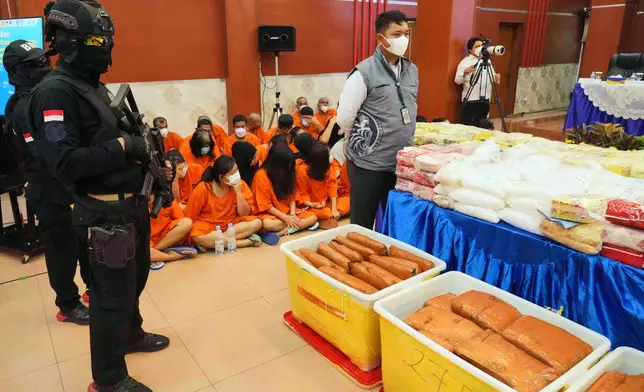 Indonesian police officers stand guard near various drugs seized in a nationwide crackdown in the past few months, before the start of a press conference at the Indonesian Customs headquarters in Jakarta, Indonesia, Monday, June 23, 2025. (AP Photo/Achmad Ibrahim)