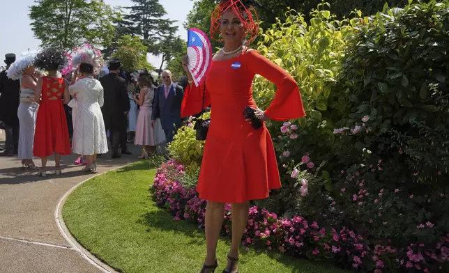 Wilnelia Merced poses for photographs holding fan with the flag of Puerto Rico on it, on the third day of the Royal Ascot horse race meeting, traditionally called Ladies Day, at Ascot, England, Thursday, June 19, 2025. (AP Photo/Kin Cheung)