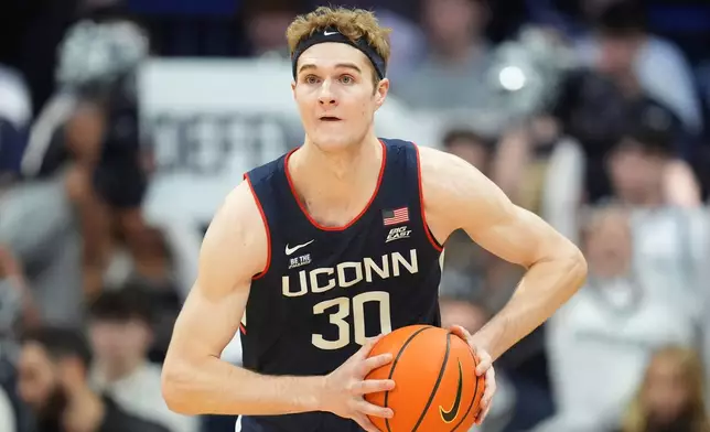 FILE - Connecticut forward Liam McNeeley (30) plays against Butler in the first half of an NCAA college basketball game in Indianapolis, Saturday, Dec. 21, 2024. (AP Photo/Michael Conroy, File)
