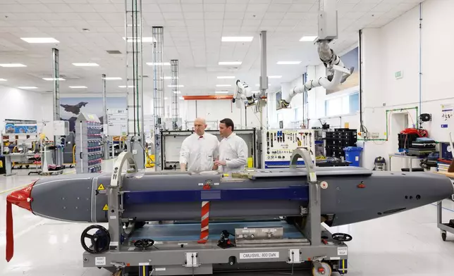 Director of Mechanical Engineering Matt Beamont, right, shows Britain's Defence Secretary John Healey a storm shadow missile on an assembly line at the MBDA Storm Shadow factory in Stevenage, England, Saturday May 31, 2025. (Dan Kitwood/Pool via AP)