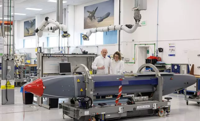 Louise Holmes, MBDA UK Deputy Managing Director, shows Britain's Defence Secretary John Healey, left, a storm shadow missile on an assembly line at the MBDA Storm Shadow factory in Stevenage, England, Saturday May 31, 2025. (Dan Kitwood/Pool via AP)