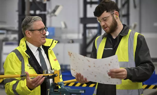 Britain's Prime Minister Keir Starmer, left, speaks to a member of staff during a visit to the BAE Systems'Govan facility, in Glasgow, Scotland, Monday June 2, 2025. (Andy Buchanan, Pool Photo via AP)