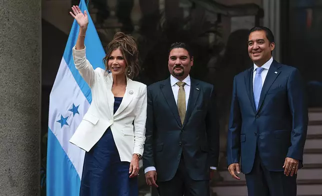 U.S. Homeland Security Secretary Kristi Noem waves alongside Honduran Foreign Minister Javier Bu, center, and presidential private secretary Hector Zelaya at the president's residence in Tegucigalpa, Honduras, Wednesday, June 25, 2025. (Anna Moneymaker/Pool photo via AP)