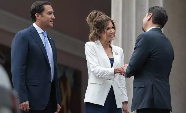 U.S. Homeland Security Secretary Kristi Noem shakes hands with Honduran Foreign Minister Javier Bu outside the president's residence in Tegucigalpa, Honduras, Wednesday, June 25, 2025. (Anna Moneymaker/Pool photo via AP)