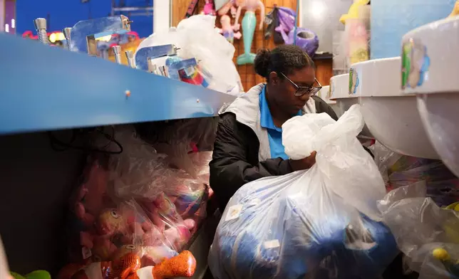 Playland's Castaway Cove booth operator Ja'Vira Blake restocks prizes at Playland's Castaway Cove amusement park, in Ocean City, N.J, on Friday, June 6, 2025. (AP Photo/Mingson Lau)