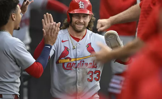 St. Louis Cardinals' Brendan Donovan (33) celebrates in the dugout with teammates after scoring on a Ivan Herrera two-RBI single during the second inning of a baseball game against the Chicago White Sox, Tuesday, June 17, 2025, in Chicago. (AP Photo/Paul Beaty)