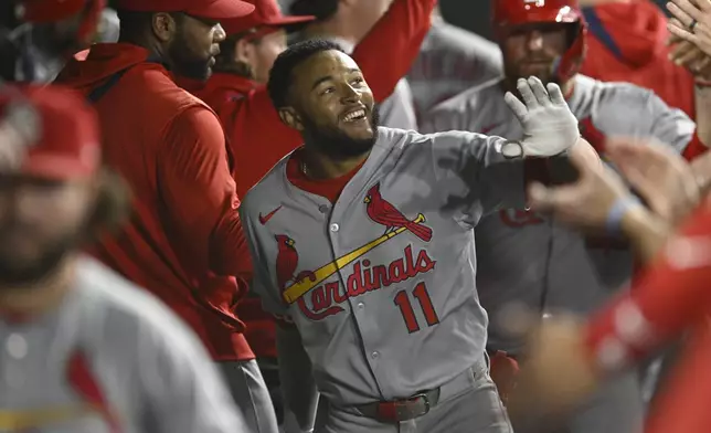 St. Louis Cardinals' Victor Scott III (11) celebrates with teammates in the dugout after hitting a two-run home run during the ninth inning of a baseball game against the Chicago White Sox, Tuesday, June 17, 2025, in Chicago. (AP Photo/Paul Beaty)