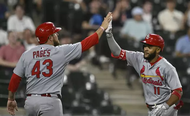 St. Louis Cardinals' Victor Scott III, right, celebrates with teammate Pedro Pages, left, after hitting a two-run home run during the ninth inning of a baseball game against the Chicago White Sox, Tuesday, June 17, 2025, in Chicago. (AP Photo/Paul Beaty)