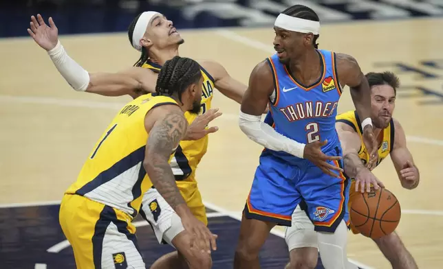 Indiana Pacers guard T.J. McConnell, right, knocks the ball away from Oklahoma City Thunder guard Shai Gilgeous-Alexander (2) as Indiana Pacers guard Andrew Nembhard defends during the first half of Game 6 of the NBA Finals basketball series, Thursday, June 19, 2025, in Indianapolis. (AP Photo/Michael Conroy)