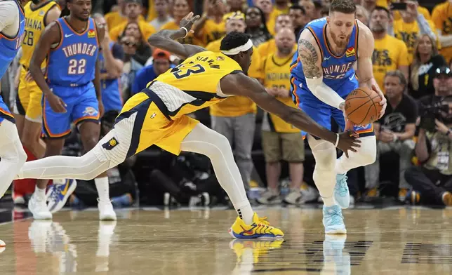 Oklahoma City Thunder center Isaiah Hartenstein (55) and Indiana Pacers forward Pascal Siakam (43) reach for the ball during the second half of Game 6 of the NBA Finals basketball series, Thursday, June 19, 2025, in Indianapolis. (AP Photo/Abbie Parr)