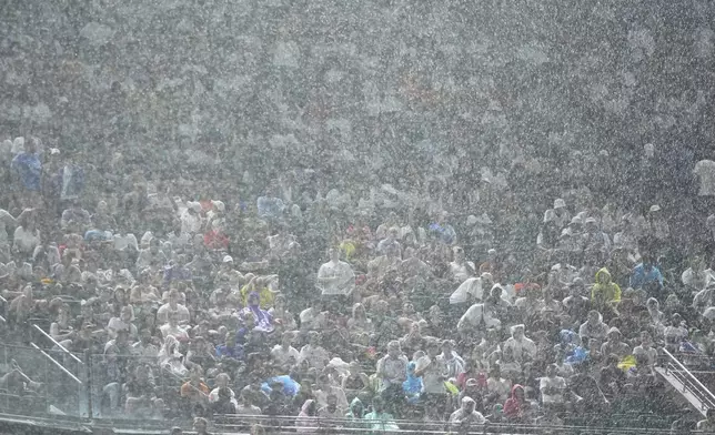 Fans sit in heavy rain as they watch the Club World Cup Group H soccer match between Salzburg and Real Madrid in Philadelphia, Thursday, June 26, 2025. (AP Photo/Matt Slocum)
