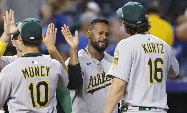 Athletics pitcher Luis Severino, center, celebrates with Nick Kurtz (16) along with Max Muncy (10) and others at the end of a baseball game against the Kansas City Royals in Kansas City, Mo., Friday, June 13, 2025. (AP Photo/Colin E. Braley)