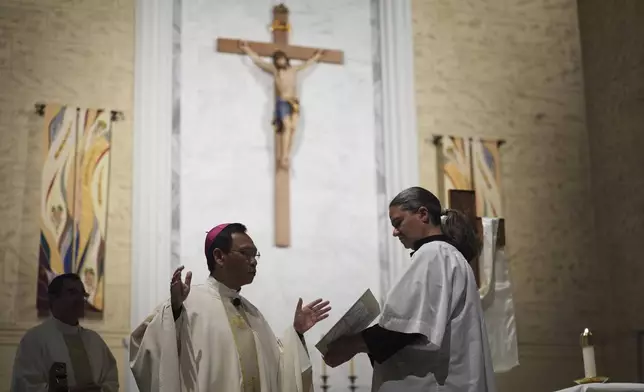 Bishop Michael Pham leads Mass before heading an interfaith group to a federal building to be present during immigration hearings, Friday, June 20, 2025, in San Diego. (AP Photo/Gregory Bull)