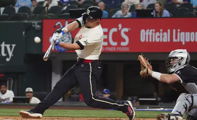 Texas Rangers' Corey Seager hits a sacrifice fly in front of Chicago White Sox catcher Kyle Teel to score teammate Josh Smith during the first inning of a baseball game, Friday, June 13, 2025, in Arlington, Texas. (AP Photo/LM Otero)
