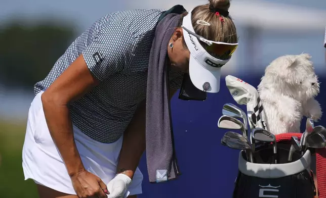 Lexi Thompson writes on her scorecard before her tee shot on the sixth hole during the second round of the Women's PGA Championship golf tournament Friday, June 20, 2025, in Frisco, Texas. (AP Photo/LM Otero)