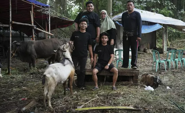 Nina Herlina, center, poses for a photo with her workers at her livestock stall in Jakarta, Indonesia, Monday, June 2, 2025. (AP Photo/Achmad Ibrahim)