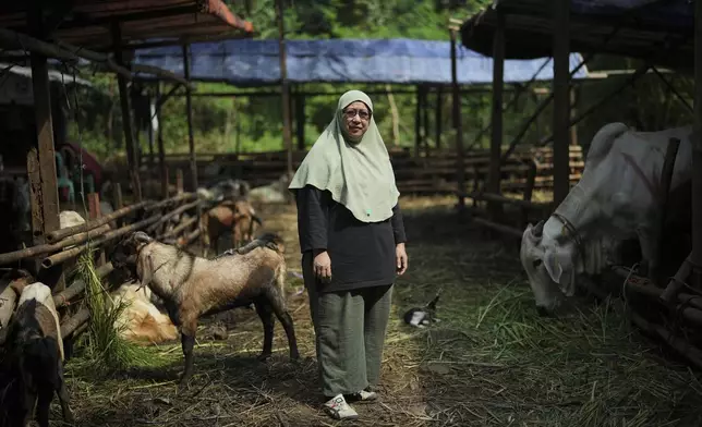 Nina Herlina poses for a photo at her livestock stall in Jakarta, Indonesia, Monday, June 2, 2025. (AP Photo/Achmad Ibrahim)