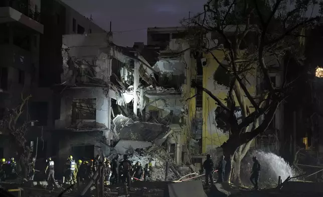 Rescue team work at the site where a missile launched from Iran struck Tel Aviv, Israel, Monday, June 16, 2025. (AP Photo/Baz Ratner)