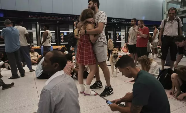 People shelter in an underground metro station as air raid sirens warn of incoming strikes by Iran, in Ramat Gan, near Tel Aviv, Israel, Wednesday, June 18, 2025. (AP Photo/Oded Balilty)