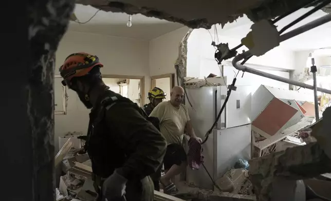 Haim Rasin is evacuated from his apartment after a direct hit from an Iranian missile strike in Ramat Gan, Israel, Thursday, June 19, 2025. (AP Photo/Oded Balilty)