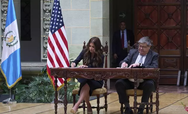 U.S. Homeland Security Secretary Kristi Noem, left, and Guatemalan Interior Minister Francisco Jimenez sign a security program agreement at the National Palace in Guatemala City, Thursday, June 26, 2025. (AP Photo/Moises Castillo)